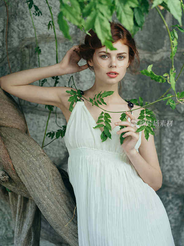 attractive red-haired Woman in white dress mythology decoration posing